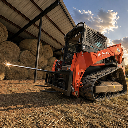 Kubota skid steer working around hay barn